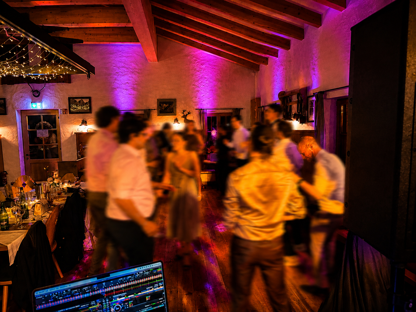 Hochzeitsparty in der Spitzingalm am Spitzingsee mit tanzenden Gästen unter warmen Lichterketten