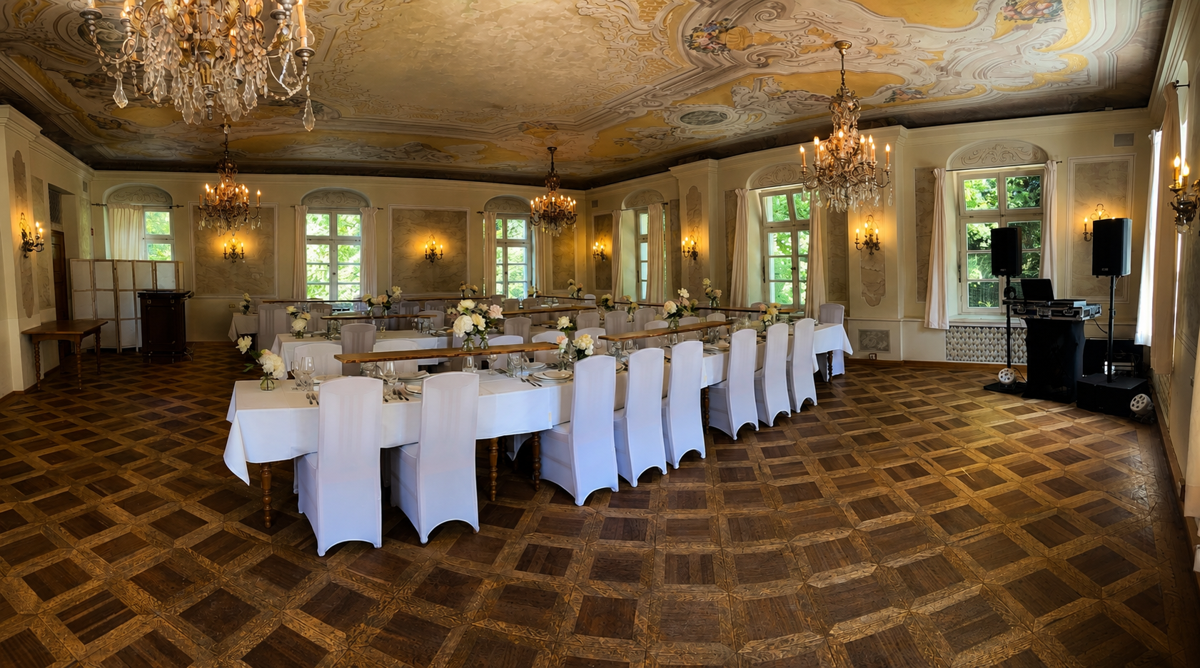 Festlich gedeckter Saal im Bamberger Haus mit Parkett, Kristallleuchtern, bemalter Decke und seitlichem DJ-Aufbau
